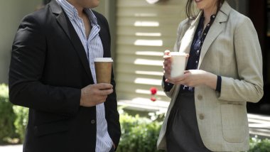 Kâğıt kahve bardakları tutan iş adamları. İş adamı ve iş kadını dışarıda kahve içiyor..