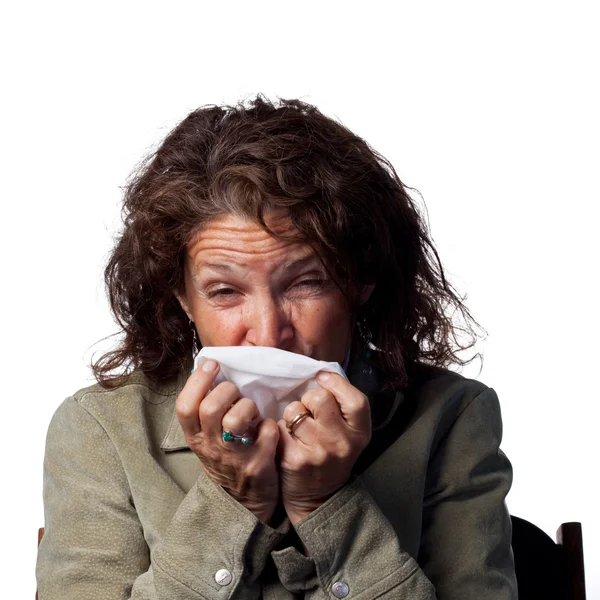 Woman sneezes into a tissue — Stock Photo, Image