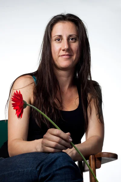 Cute young woman with flower in hand — Stock Photo, Image