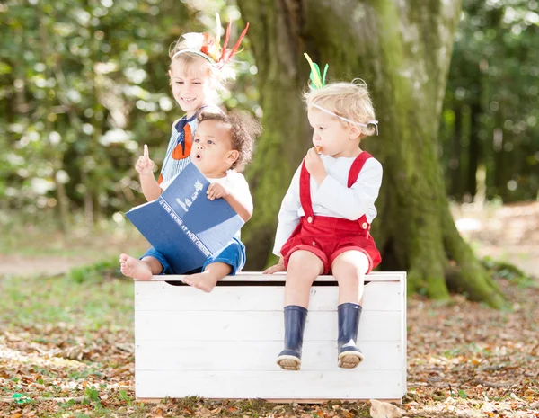Children reading together in woods
