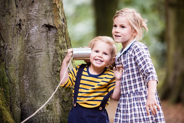 Children listening with a  tin can. — Stock Photo, Image