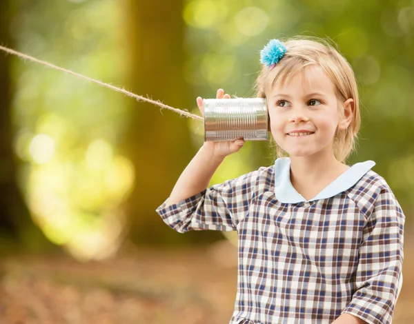 Girl listening on a tin can communicator. — Stock Photo, Image