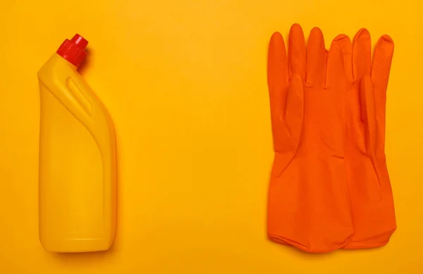 Желтая бутылка унитаза и оранжевые резиновые перчатки Лицензионные Стоковые Фото