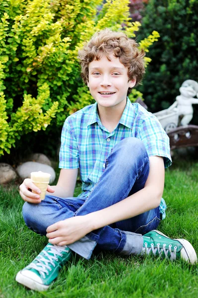Adolescente chico es comer su helado . — Foto de Stock