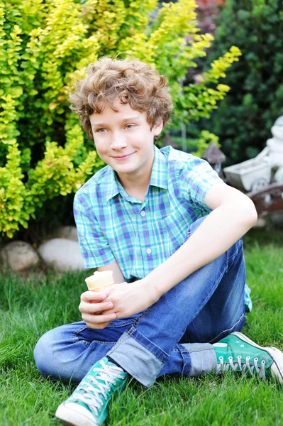 Adolescente chico es comer su helado . — Foto de Stock