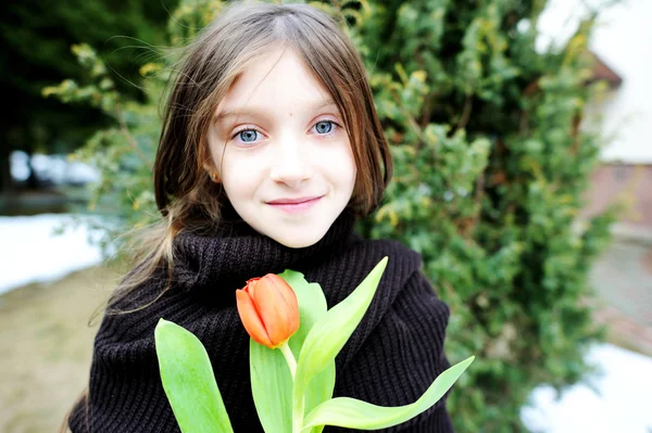 Brunette jongen meisje met tulpen buiten — Stockfoto