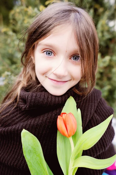Bruneta dítě dívka s tulipány mimo — Stock fotografie
