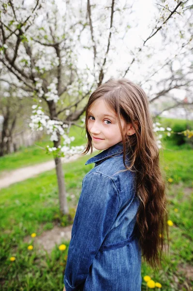 Kid girl in blooming garden — Stock Photo, Image