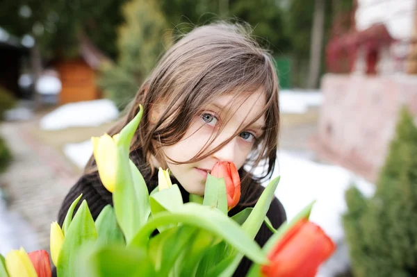 Brunette kid girl with tulips outside — Stock Photo, Image