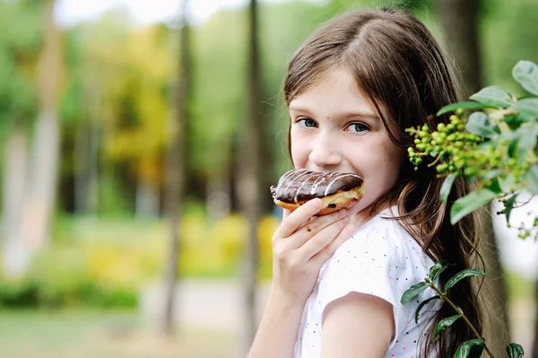 Cute kid girl eating sweet donuts