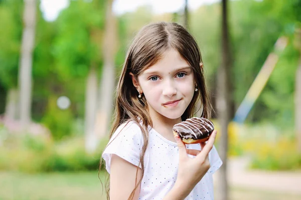 Cute kid girl eating sweet donuts — Stock Photo, Image