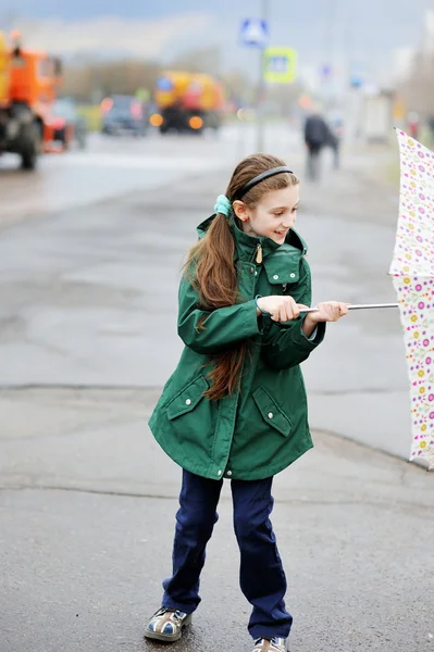 Mädchen mit Regenschirm läuft in Stadtstraße — Stockfoto