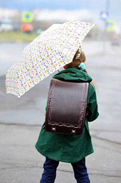 Девочка с зонтиком гуляет по городской улице — стоковое фото