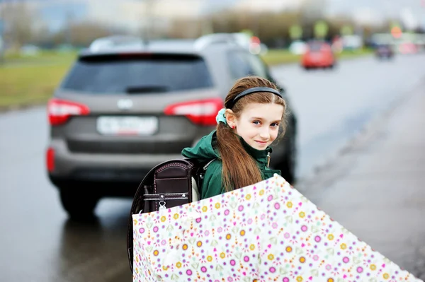 Niña con paraguas caminando en la calle de la ciudad — Foto de Stock