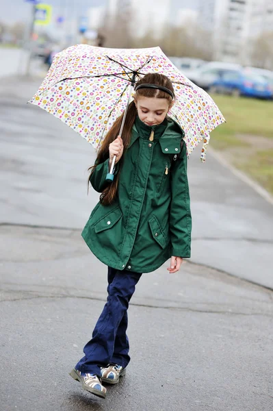 Kid flicka med paraply promenader i stad gatan — Stockfoto