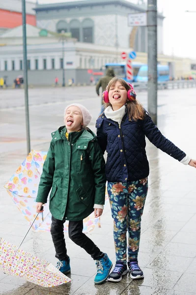 Niedliche 10-jährige Mädchen mit Regenschirmen Stockbild
