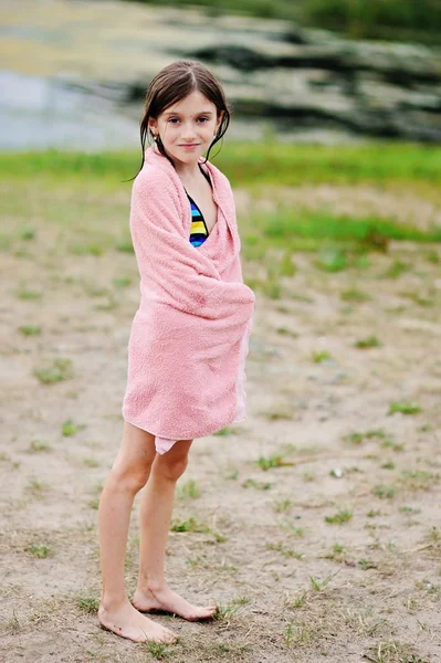 Menina bonito na praia coberto com toalha — Fotografia de Stock