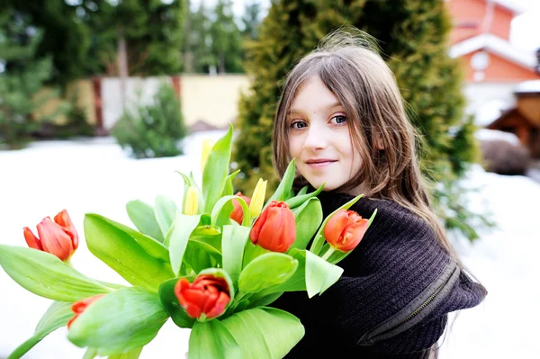 Brunette jongen meisje met tulpen buiten — Stockfoto