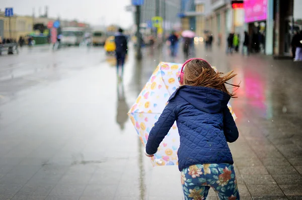 Kid flicka med paraply promenader i stad gatan — Stockfoto