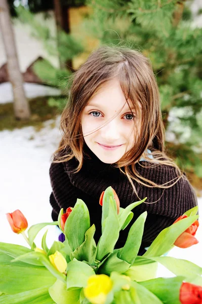 Brunette kid girl with tulips outside — Stock Photo, Image