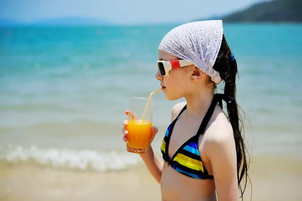 Kid girl with juice on the beach — Stock Photo, Image