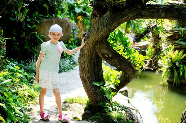 Pretty european kid girl in tropical park — Stock Photo, Image