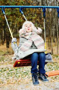Güzel kış günü, bir salıncak üzerinde kız çocuk