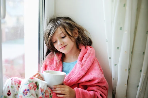 Hermosa niña en albornoz con taza de té —  Fotos de Stock