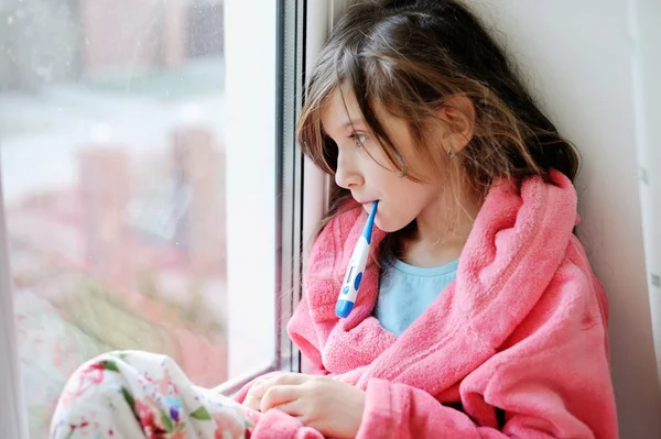 Ill criança menina segurando termômetro — Fotografia de Stock