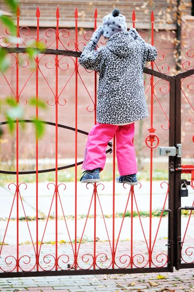 Kluk holka vyšplhal na plot — Stock fotografie