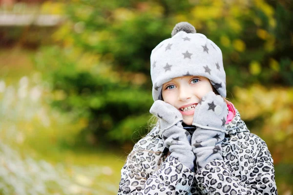 Kid girl has fun in garden with first snow — Stock Photo, Image