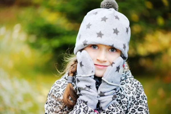 Kid flicka har kul i trädgården med första snön — Stockfoto