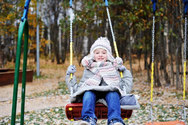 Kid flicka på en gunga på vackra vinterdag — Stockfoto