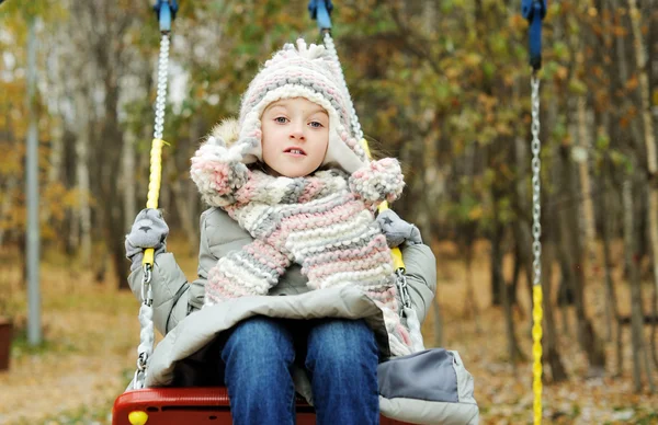 Kluk holka na houpačce na krásný zimní den — Stock fotografie