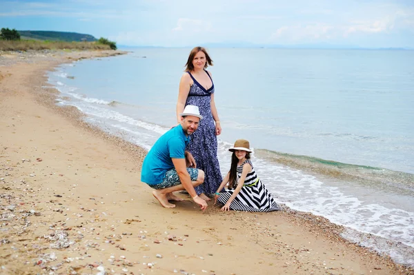 Veduta della giovane famiglia che si diverte sulla spiaggia — Foto Stock