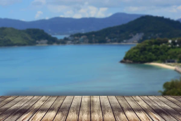 Tabel kayu di atas pada latar belakang laut biru kabur untuk menampilkan yo — Stok Foto