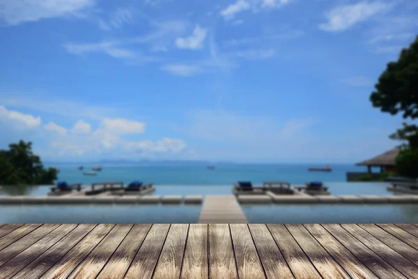 Mesa de madera sobre fondo azul borroso — Foto de Stock