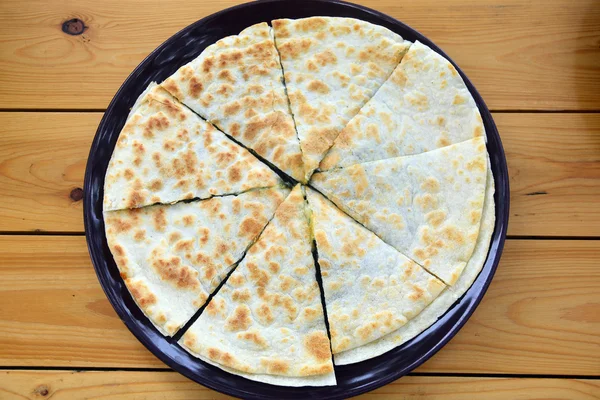 Tortilla con espinacas en una sartén colocada sobre una mesa — Foto de Stock