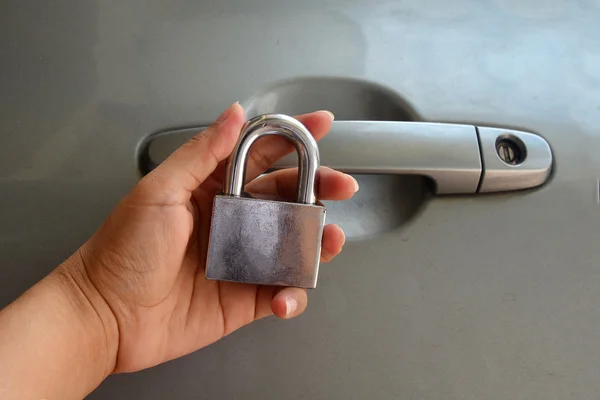 Mão segurando fechadura de metal isolado no fundo branco - Segurança — Fotografia de Stock