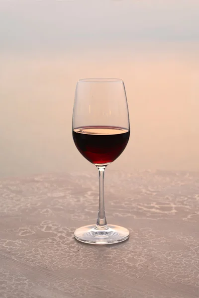 Glass of wine at sunset on the sea — Stock Photo, Image