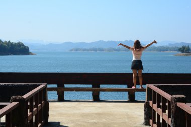 Bir iskelede nehir üzerinde rahatlatıcı kadın.