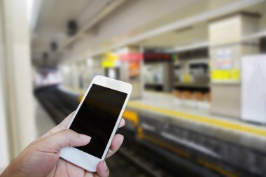 Adam dokunmatik ekran eller yukarıda kapalı. Tren istasyonunun arka plan