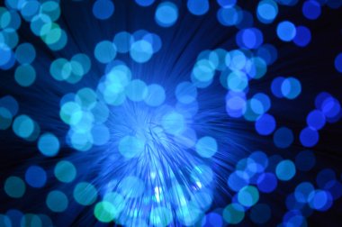 Fiber optik kabloların aynı sahnesinin renk değiştiren görüntülerinden oluşan mavi soyut bir arkaplan.