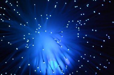 Fiber optik kabloların aynı sahnesinin renk değiştiren görüntülerinden oluşan mavi soyut bir arkaplan.