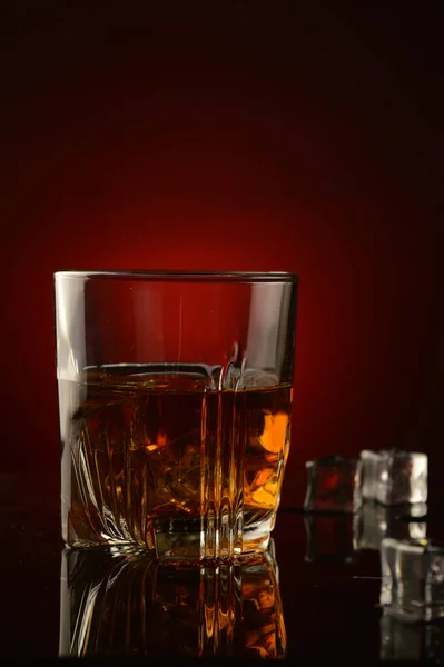 Eine Nahaufnahme Eines Glases Voll Whiskey Und Eis Vor Dunkelrotem — Stockfoto