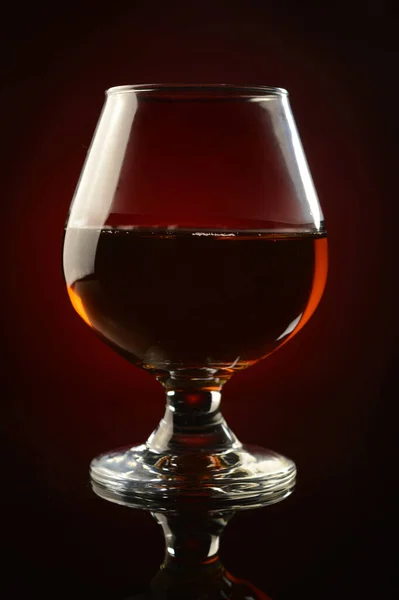 Uma Composição Vertical Copo Cognac Sobre Fundo Vermelho Preto Reflexivo — Fotografia de Stock