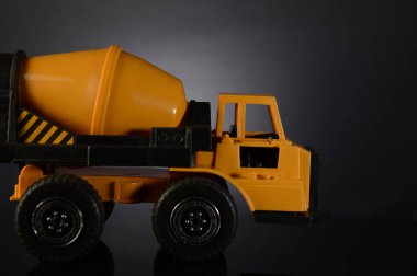 Bir oyuncak çimento karıştırıcısı görüntünün sol tarafından çerçeveye giriyor.