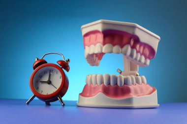 Diş hekimi için bir saat ve diş görüntüsü.
