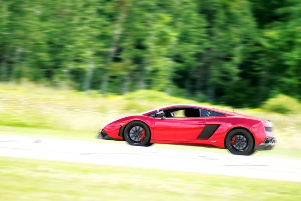 Using a panning photography technique I was able to capture this lamborghini on the track, which had a radar reading of just over 200 miles per hour. — Stock Photo, Image