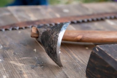 Testerenin arka planında marangoz ustasının tezgahında metal bir alet var.
